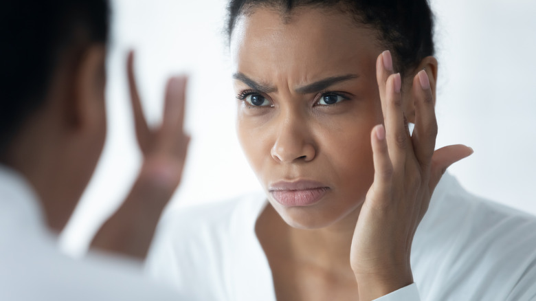 Person frowning with hand to head