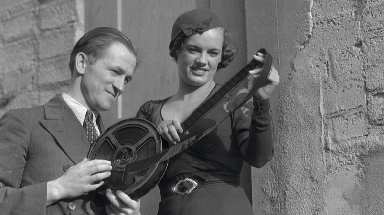 Man and woman looking at celluloid film reel