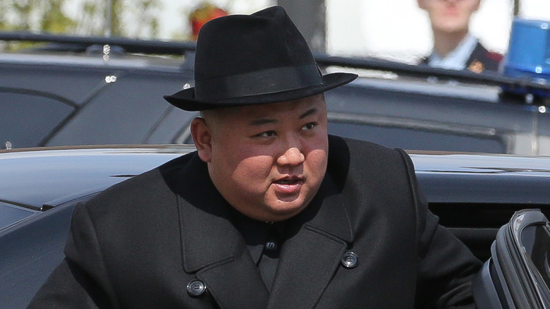 Kim Jong-un in dark suit and hat