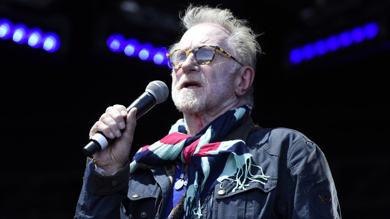 Andrew Loog Oldham holding microphone