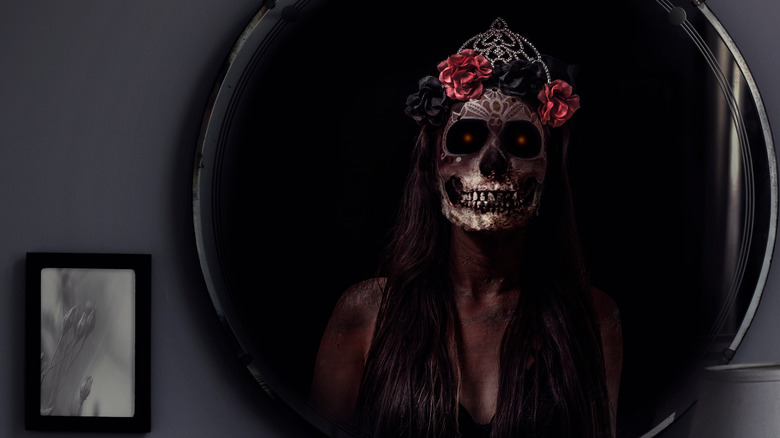 Skeleton with roses on head reflected in mirror