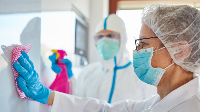 People wearing protective masks while cleaning