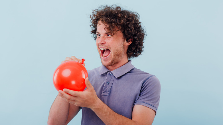 Laughing person holding balloon