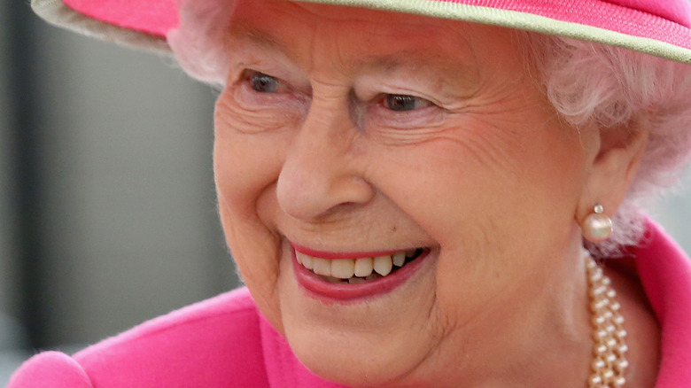 Queen Elizabeth II smiling pink