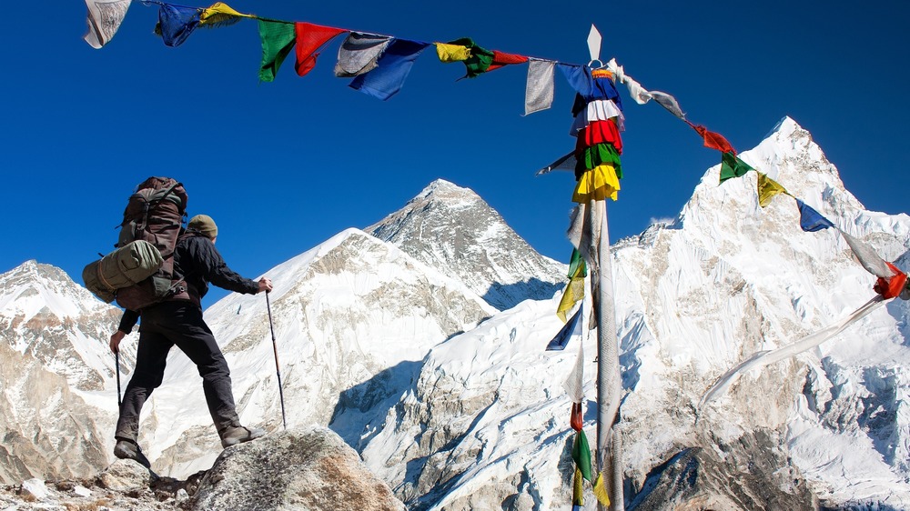 Climber beneath prayer flags on Mt Everest