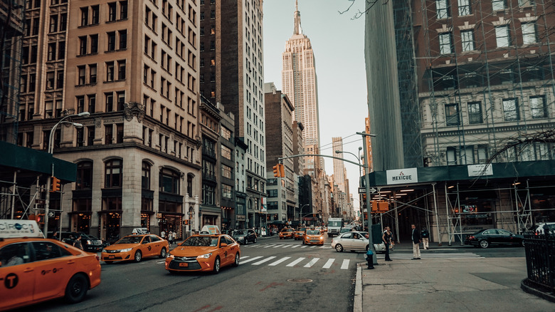 Уличная сцена Нью-Йорка с Эмпайр Стейт Билдинг на расстоянии