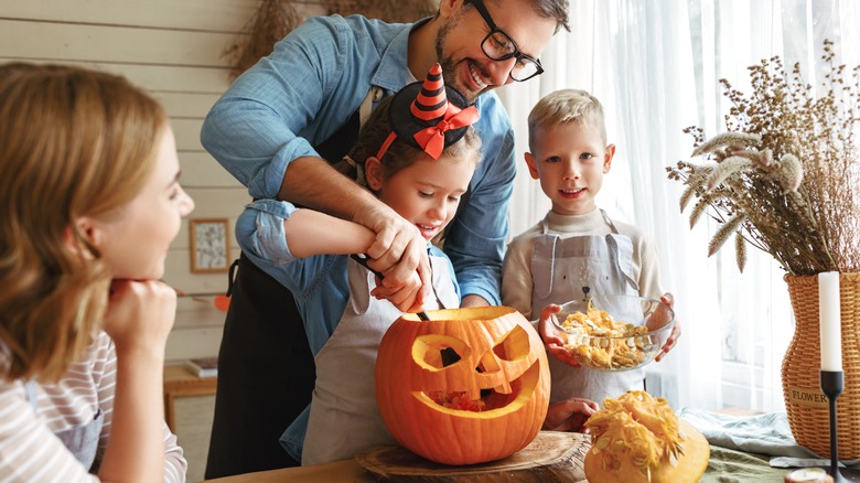 family carving pumpkin