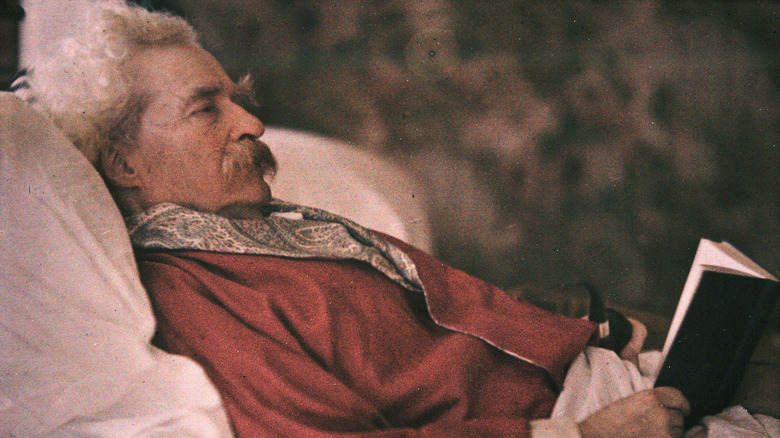 Mark Twain lying bed reading book