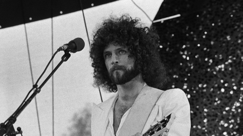 Lindsey Buckingham in white shirt performing on stage