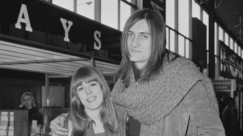 Jenny Boyd and Mick Fleetwood hugging and smiling in street