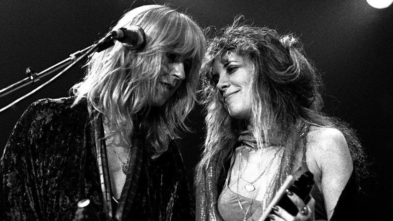 Christine McVie and Stevie Nicks performing on stage looking at each other