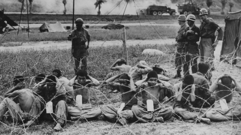 North Korean prisoners sitting behind wire