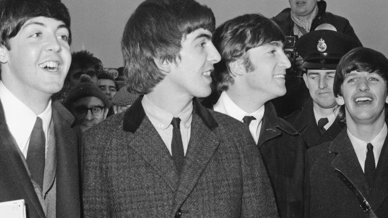 The Beatles standing in crowd