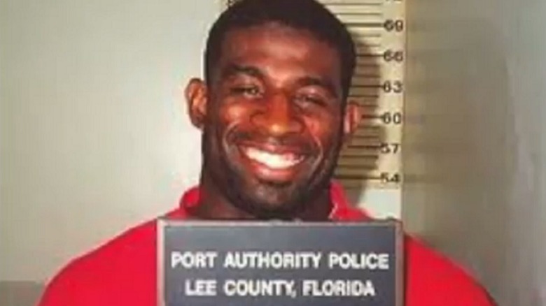 Deion Sanders smiling in mugshot