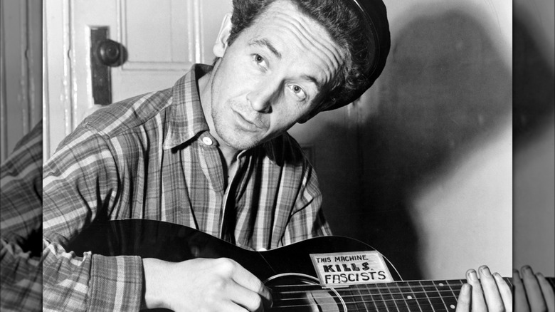 Woody Guthrie with his famous guitar