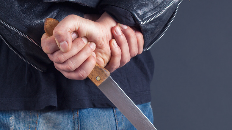 Man with knife behind his back