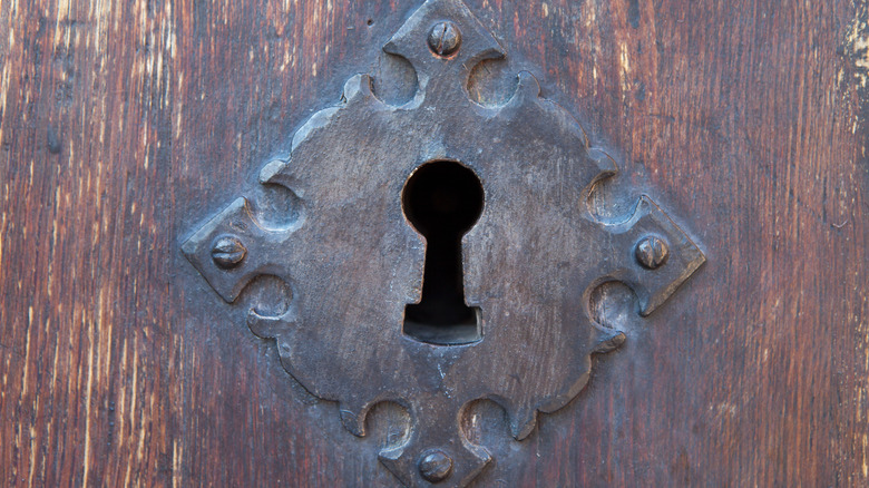 Old lock and keyhole on wooden door