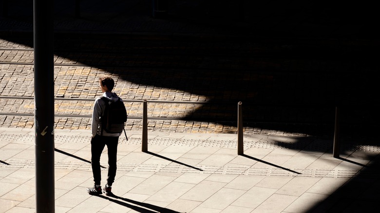 teen boy waiting for a bus