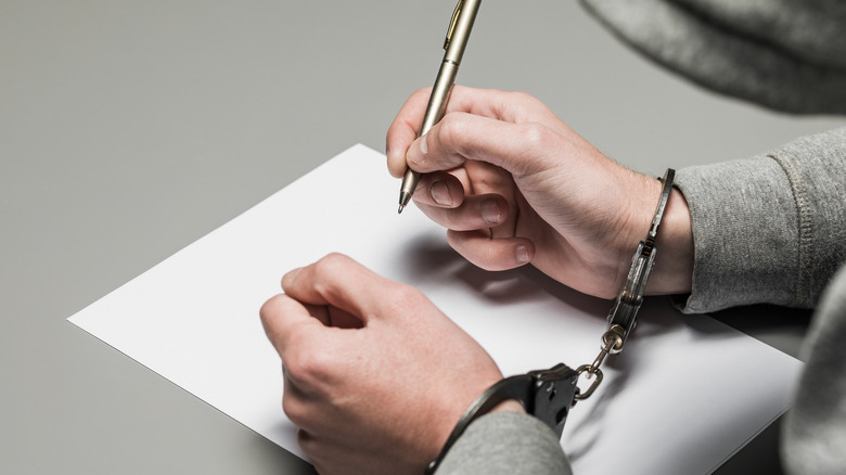 person in handcuffs with pen