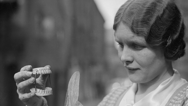 woman looking at false teeth