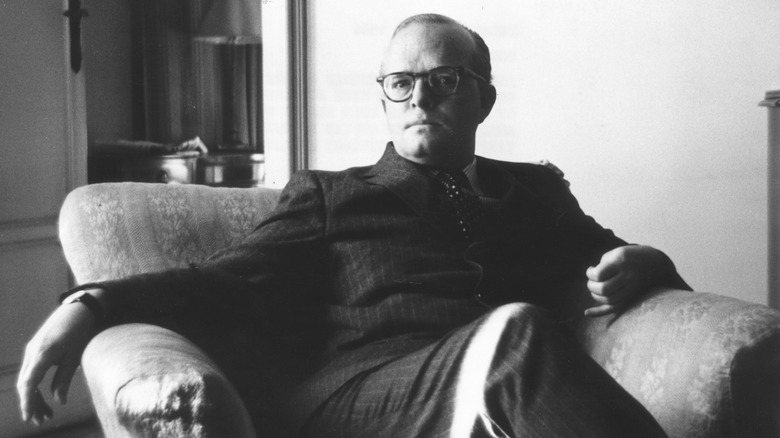 Truman Capote suit glasses reclining lounge chair