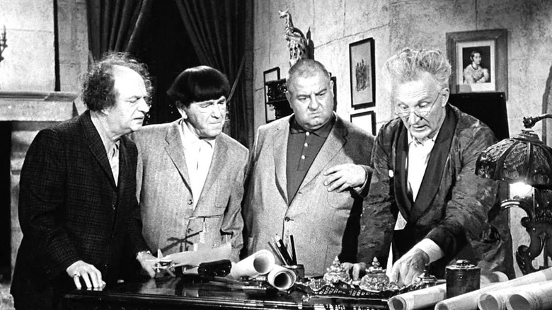 The Three Stooges gathered around a table