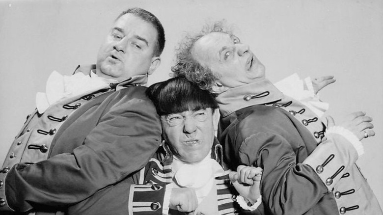 Three Stooges lean on each other