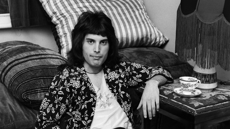 Freddie Mercury reclining on carpet