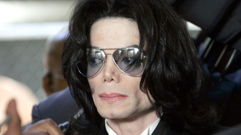 Michael Jackson in sunglasses serious surrounded in crowd