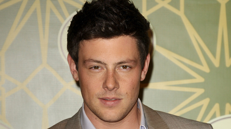 Cory Monteith posing in front of a Fox 2010 banner