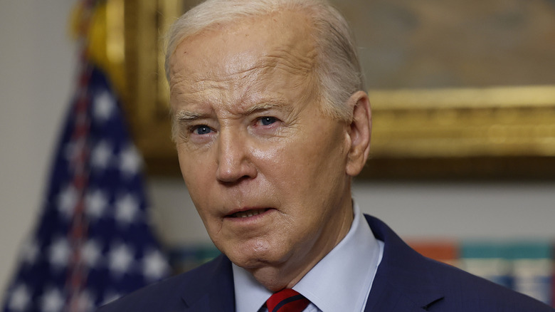 Joe Biden standing in front of a flag