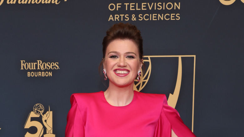 Kelly Clarkson smiling in a pink dress at event