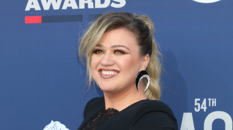 Kelly Clarkson turned and smiling in black dress