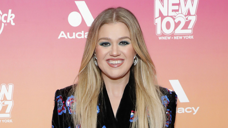 Kelly Clarkson smiling in floral print shirt at event