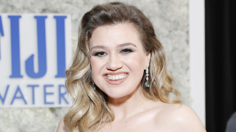 Kelly Clarkson smiling in white dress at event