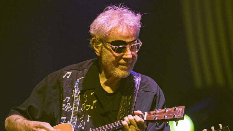 Richard Williams of Kansas plays guitar wearing glasses and eyepatch