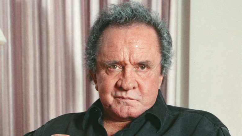 Johnny Cash sneering in front of curtains