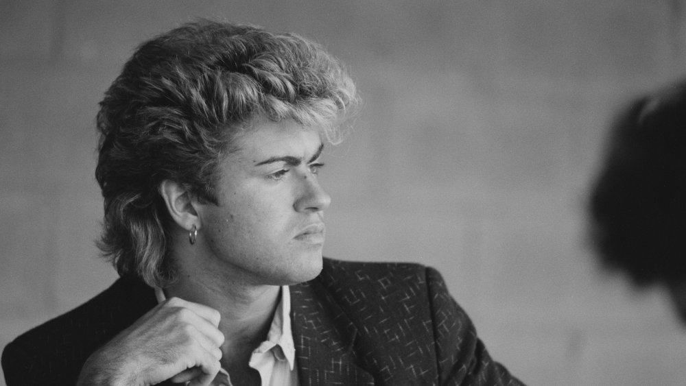 A black-and-white shot of a pensive looking George Michael