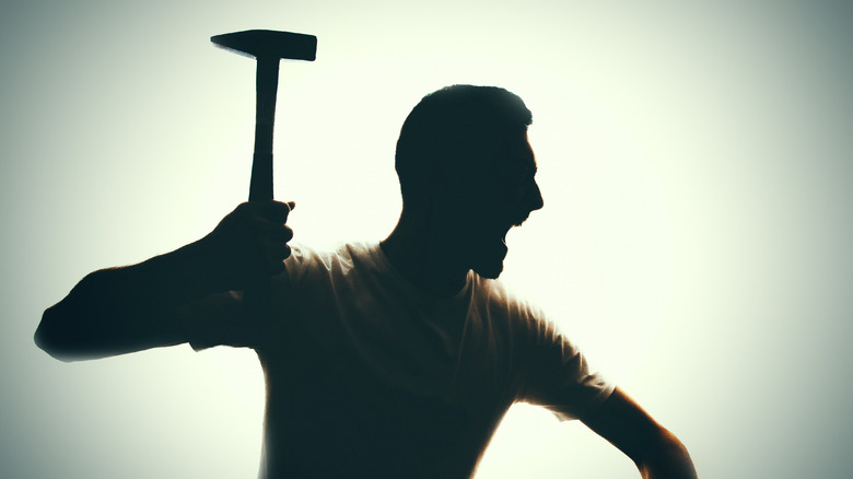 silhouette of man holding hammer
