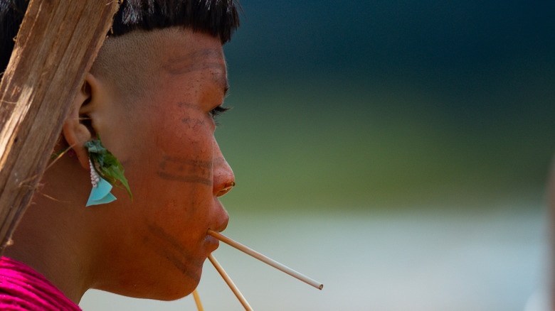 Yanomami woman carries son rainforest brazil