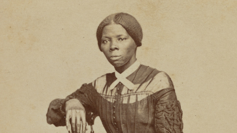 Harriet Tubman sitting on a wooden chair posing for photograph