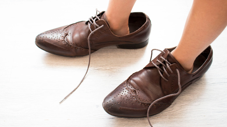 child wearing big shoes