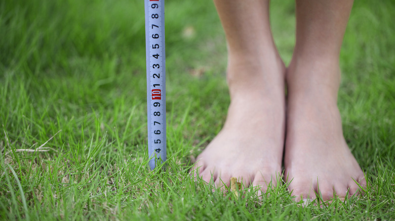 person's feet with tape measure