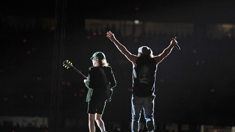 AC/DC's Angus Young and Brian Johnson from the back in silhouette