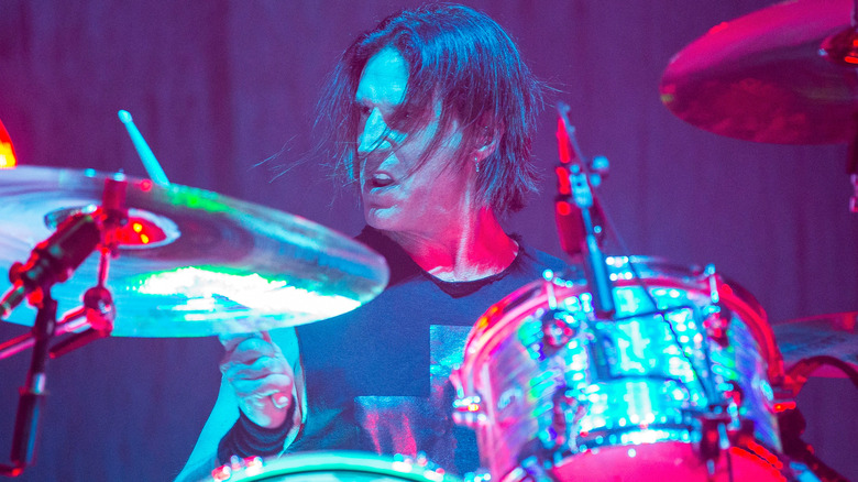 Sean Kinney sneering while playing drums