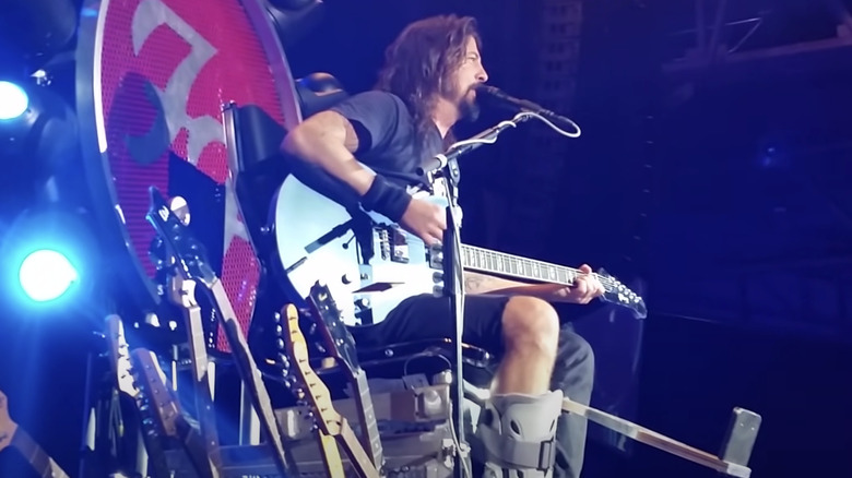 Dave Grohl on stage throne with broken leg