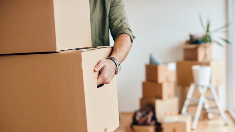 man with carton boxes moving into new home.