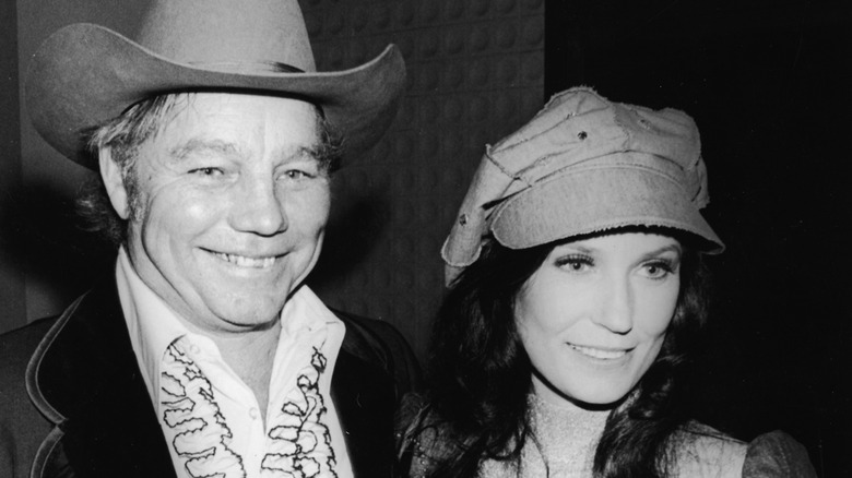 Loretta Lynn and Mooney Lynn smiling and wearing hats