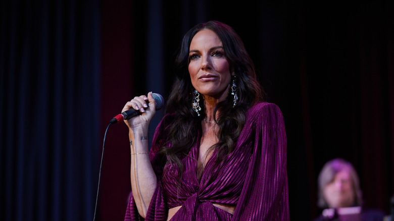 Tayla lynn in purple dress holding mic onstage