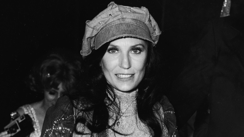 Loretta Lynn smiling wearing a hat at event